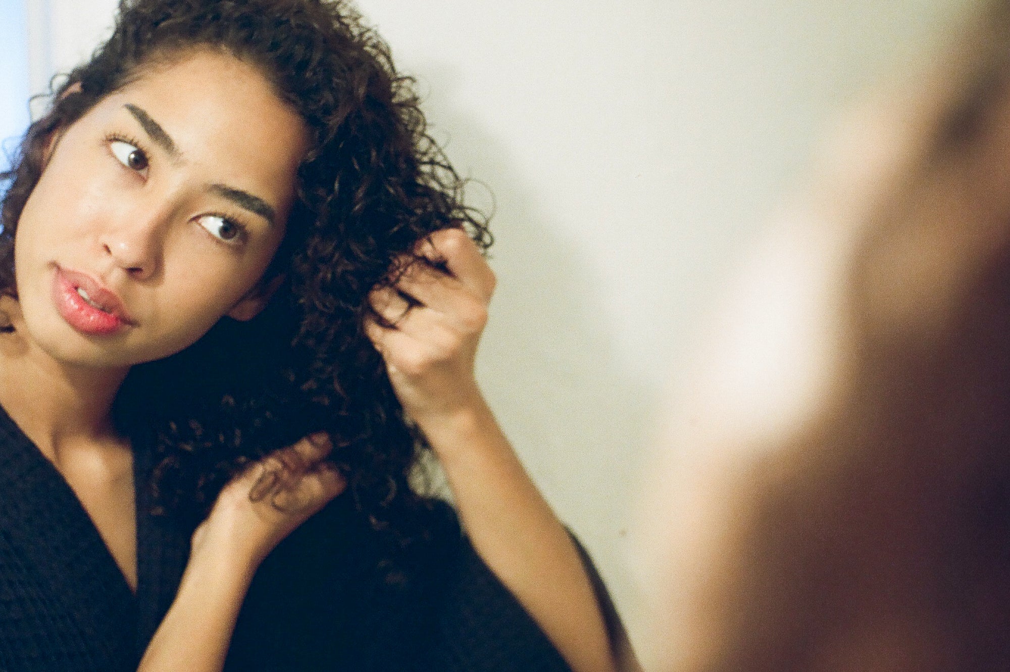 Girl with curly permed hair scrunching